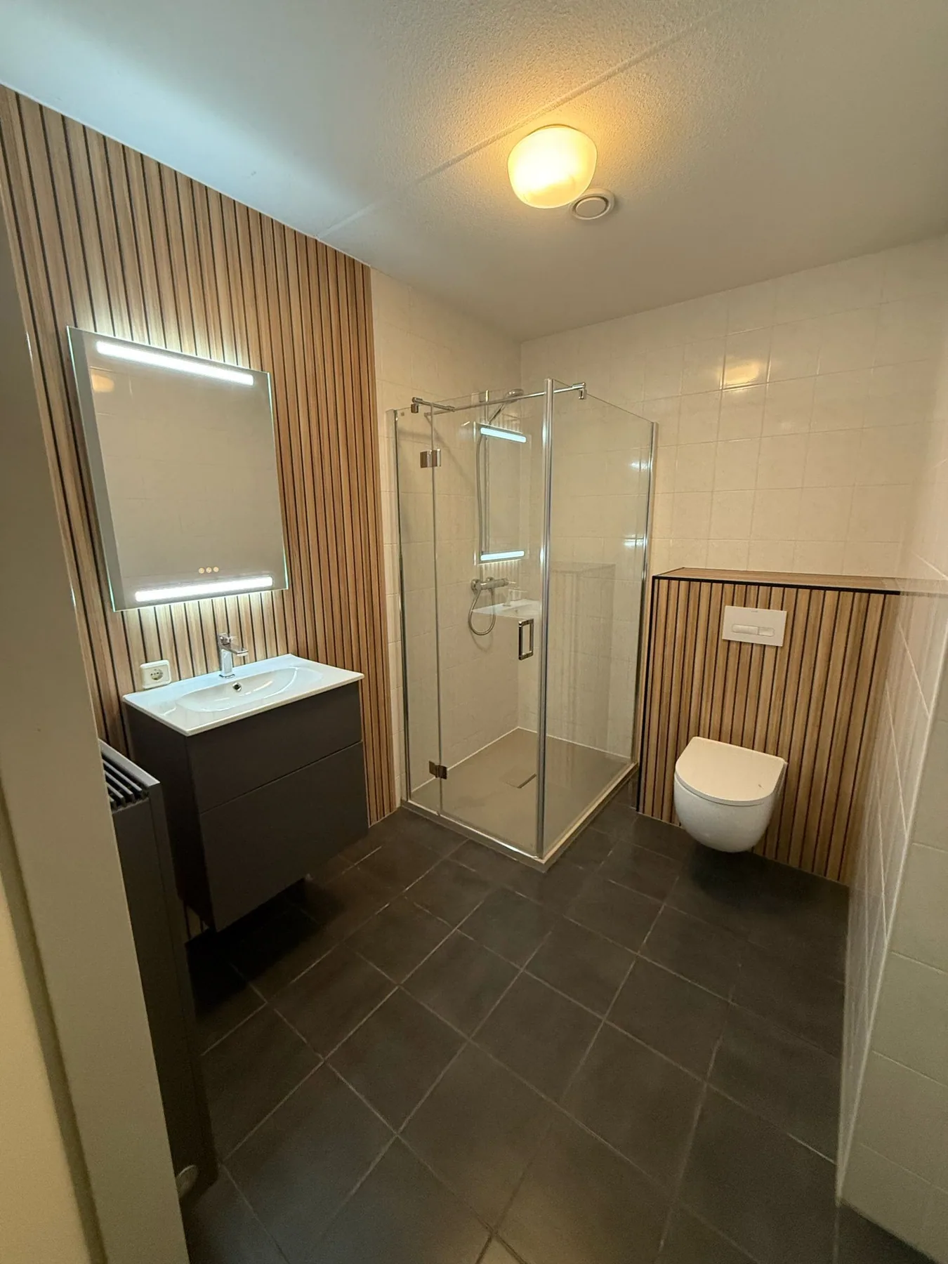 Complete badkamer met houtlook lamellen, LED-spiegel, douchecabine en hangtoilet