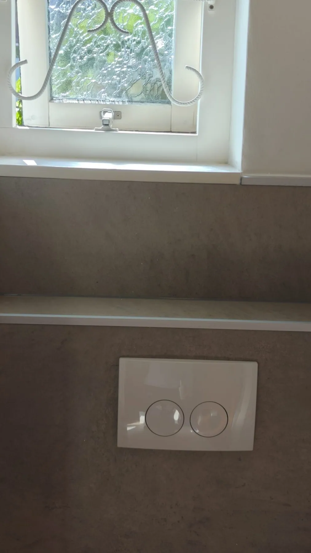 Bedieningsplaat op een betonlook voorzetwand, strak afgewerkt