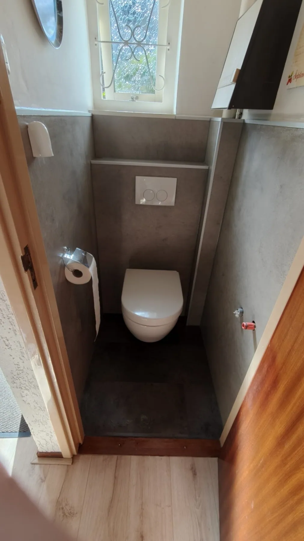 Toilet met hangtoilet, grijze betonlook wandpanelen en voorzetwand met bedieningsplaat