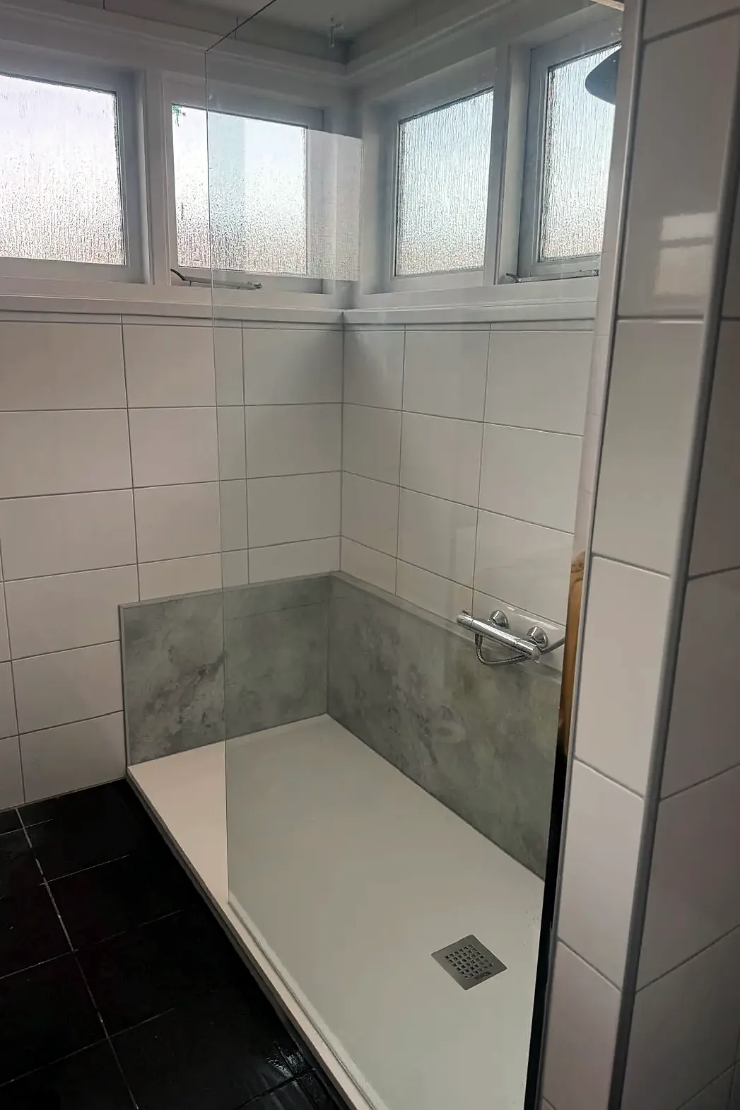 Op de plek van het bad een douche met marmerlook wandpaneel