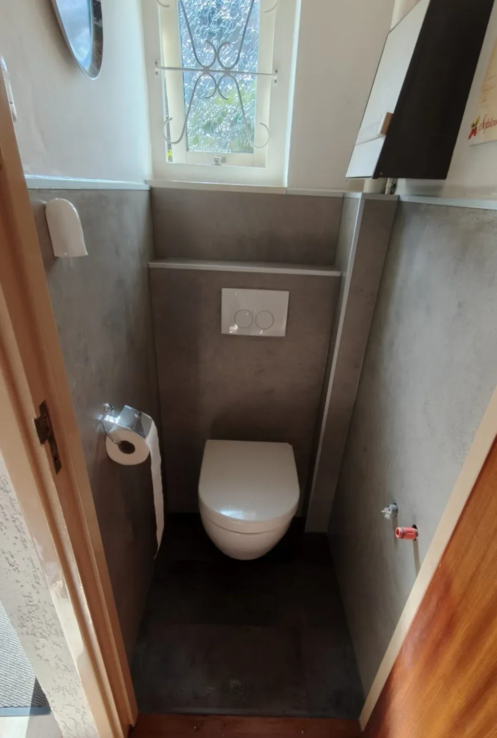 Hetzelfde toilet met hangtoilet, voorzetwand en grijze betonlook wandpanelen